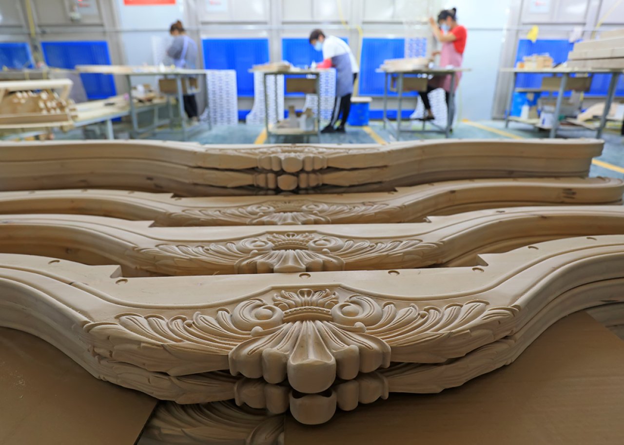 Carved wooden parts of a furniture set lined for production.