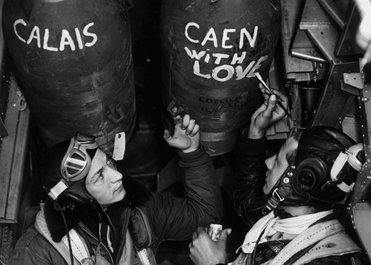 Airmen of the U.S. 8th AAF paint their bombs before setting off for a raid over Caen and Calais, France, on June 12, 1944.