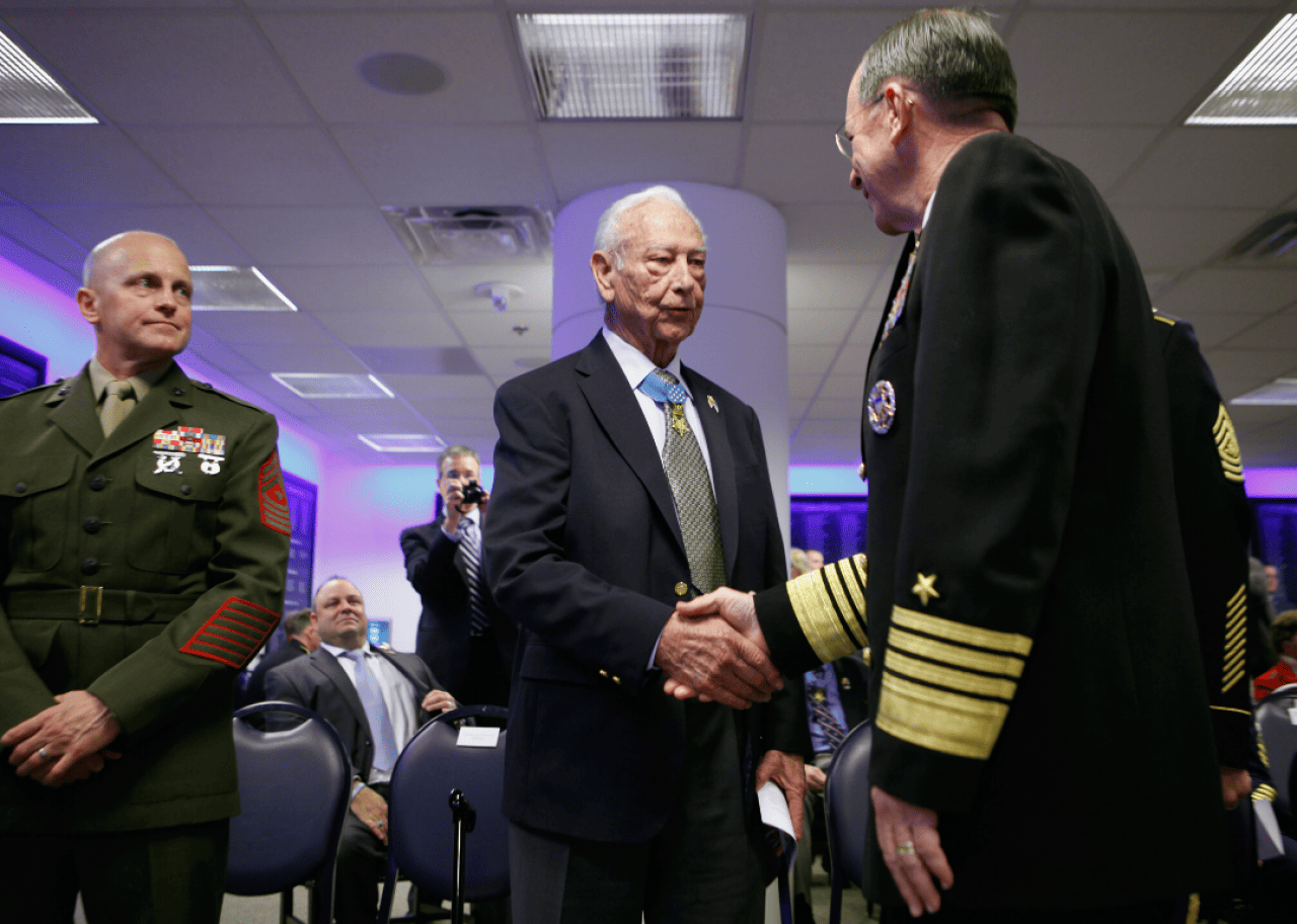 Chairman of the Joint Chiefs of Staff Admiral Mike Mullen (R) greets Medal of Honor recipient U.S. Army Staff Sgt. (retired) Walter Ehlers (C) during a ceremony in Arlington, Virginia, in 2011.